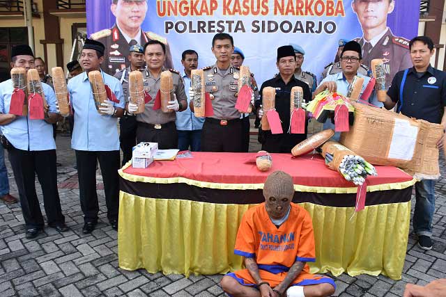 Rizky Pratama Putra (27) alias Kiko dan barang bukt ganja yang disita polisi. foto: Catur Andy Erlambang/ bangsaonline.com