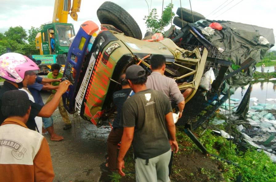 Proses evakuasi truk yang tercebur ke tambak harus menggunakan alat berat. foto: suwandi/harian bangsa