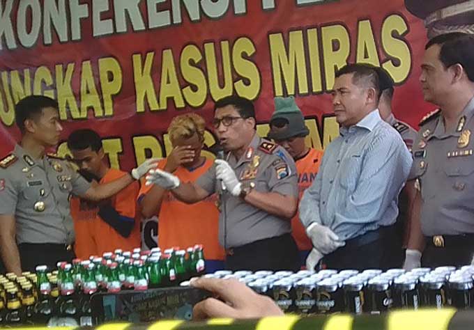 Kapolda Jatim menunjukkan miras oplosan yang memakai botol bir hitam dan kaleng mirip dengan aslinya.