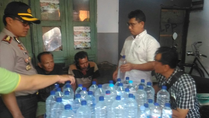 Kasat Reskrim bersama Kapolresta Kediri AKBP Anthon Haryadi saat menggerebeg rumah produsen miras oplosan. Foto: ARIF K/BANGSAONLINE