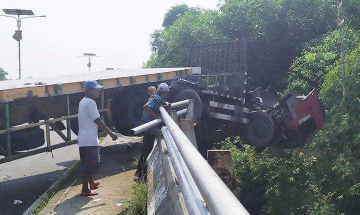 Kondisi truk kontainer yang nyaris kejebur sungai. foto: Aan Amrulloh/ BANGSAONLINE