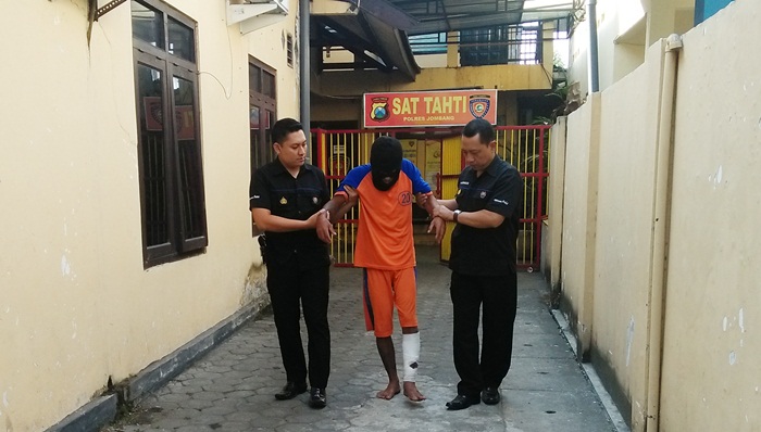 Pelaku perampasan sepeda motor dan HP saat dipapah petugas. Foto: RONY S/BANGSAONLINE