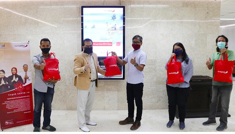 Ferdian Timur Satyagraha (jas cokelat), Pgs Direktur Utama Bank Jatim tetap menerapkan physical distancing saat memberikan paket kesehatan kepada wartawan di Kantor Pusat Bank Jatim. (foto: istimewa).