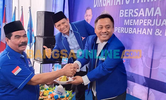 Ketua Bappilu Demokrat Jatim, Samwil, dan Ketua Demokrat Gresik, Supriyanto, saat menyerahkan potongan tumpeng kepada Ketua Fraksi Demakrat DPRD Gresik, Suberi. Foto: SYUHUD/BANGSAONLINE