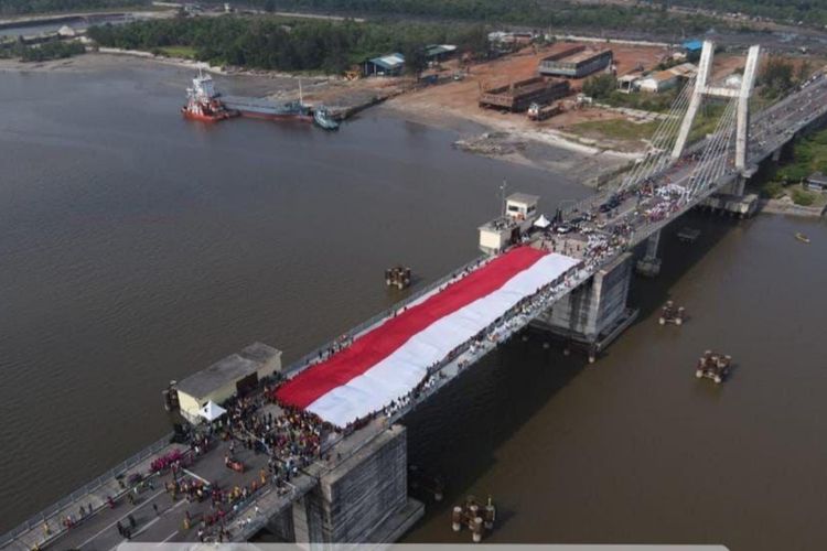 Masyarakat Babel Bentangkan Bendera Merah Putih 78 Meter di Jembatan Emas