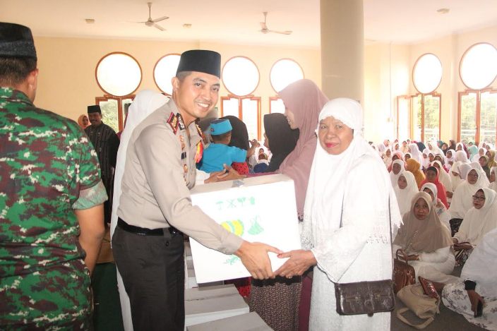Kapolres AKPB Wahyu Sri Bintoro saat memberikan bingkisan kepada anak yatim piatu dan janda. foto: SYUHUD/ BANGSAONLINE