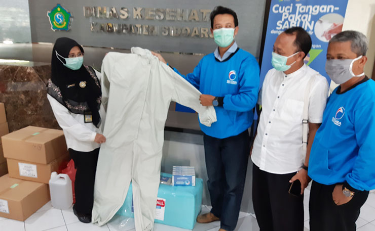 PEDULI: Pengurus Partai Gelora Sidoarjo menyerahkan baju hazmat dan masker di Kantor Dinkes, Rabu (15/4). foto: MUSTAIN/ BANGSAONLINE