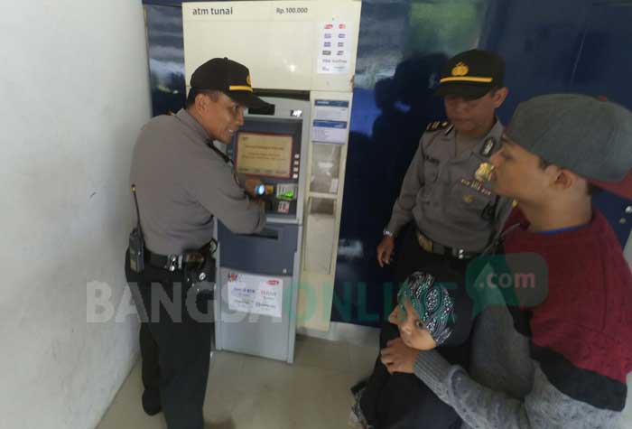Polisi saat melakukan pemeriksaan mesin ATM di sekitar Ponpes Tebuireng, Jombang, Senin (19/3/2018). foto: RONY S/ BANGSAONLINE