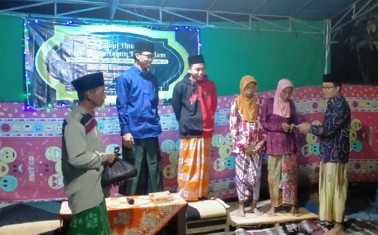 Ustadz Mahbubi mewakili. Kepala Desa Kertagena Laok saat menyerahkan santunan.