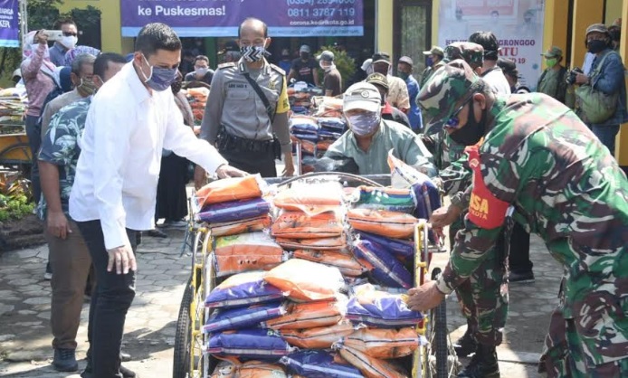 Wali Kota Kediri Abdullah Abu Bakar, saat membantu mendorong becak yang akan menyalurkan bantun dibantu aparat TNI dan Polri.