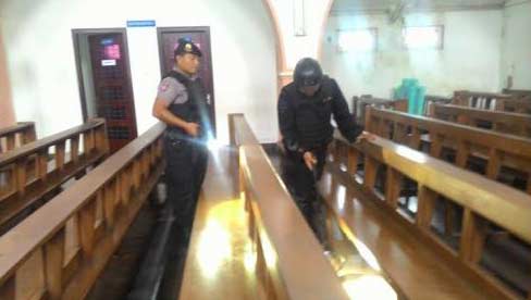ANTISIPASI: Personil Polres Madiun Kota saat menyisir salah satu gereja di kawasan Kota Madiun. foto: beritajatim