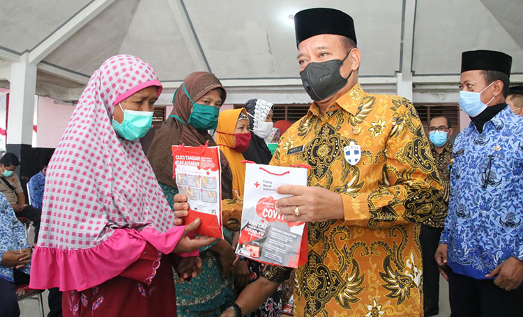 Bupati Fadeli saat menyerahkan bantuan sembako. (foto: ist)