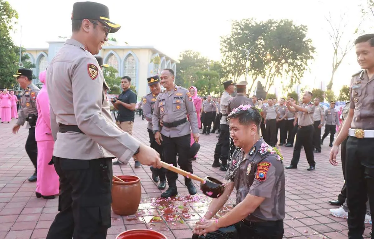 Personel yang naik pangkat dimandikan dengan air kembang. Foto: Ist