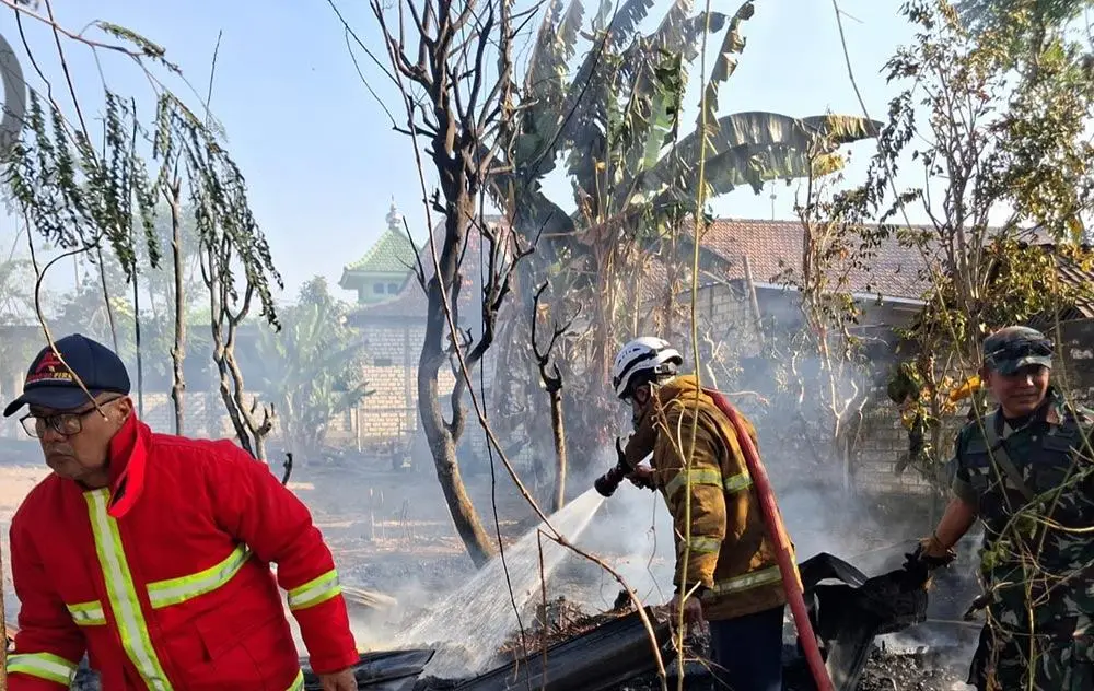 Petugas Damkar Tuban saat melakukan pemadam kabakaran pada kandang. 