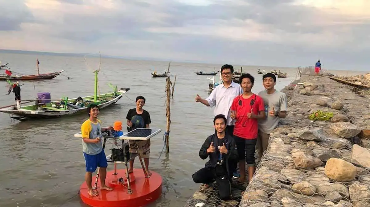 Guru Besar Departemen Teknik Fisika FTIRS ITS, Syamsul Arifin (kemeja putih), bersama mahasiswa saat uji coba operasional stasiun cuaca terapung pintar Buoy Weather Tipe II di Pantai Kenjeran, Surabaya.