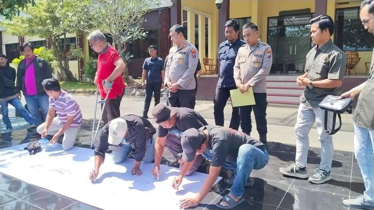 Penandatanganan pernyataan sikap bersama antara Kapolres Bangkalan dan wartawan, sebagai simbol dukungan terhadap kebebasan pers.