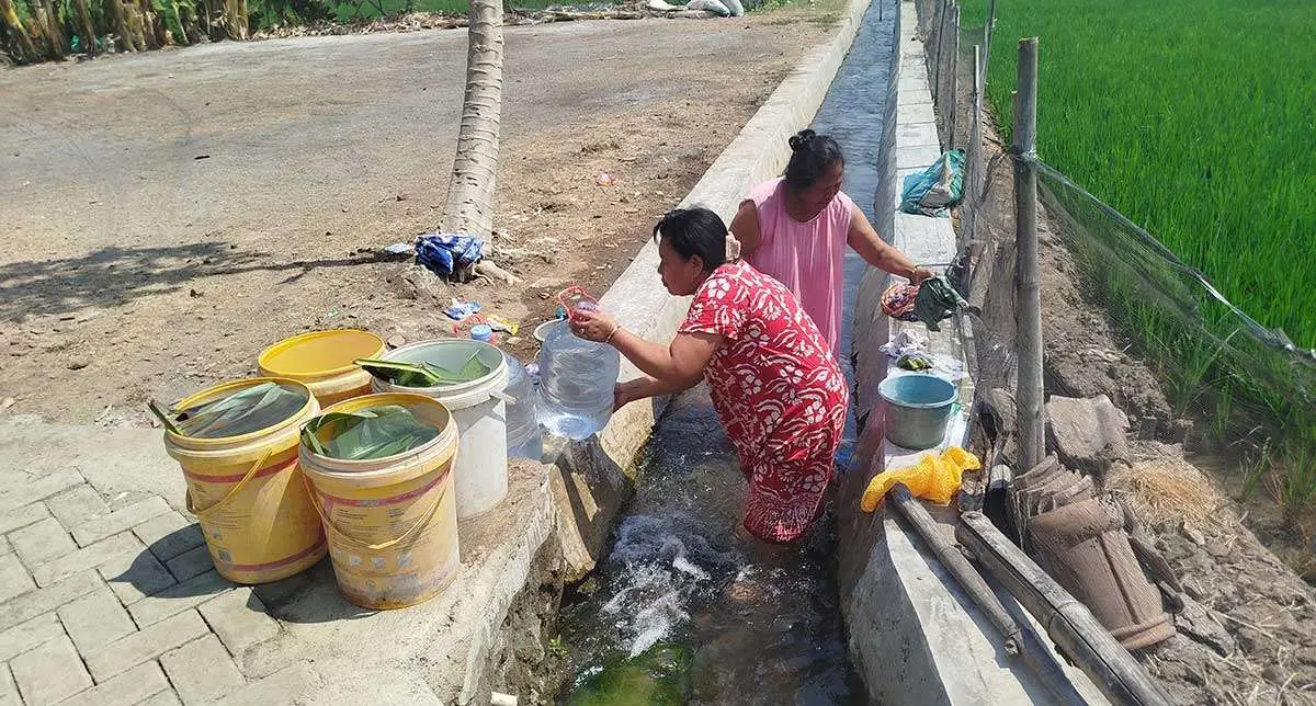 Warga ketika mengambil air dari saluran irigasi.