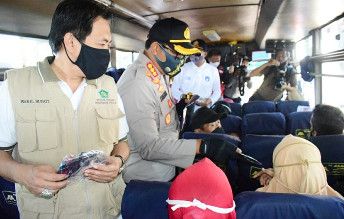 Wabup Nur Ahmad dan Kombes Pol Sumardji sedang membagikan masker kepada para penumpang bus di Terminal Bungurasih.