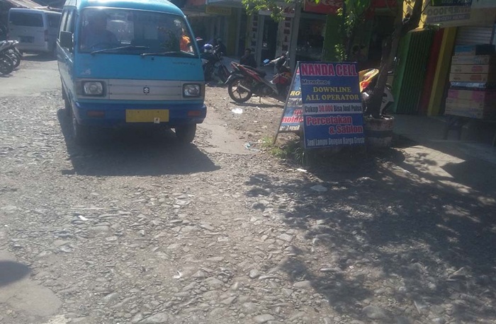 Akses jalan di pasar pandaan yang rusak parah dan sering digenangi limbah dari lapak pedagang.