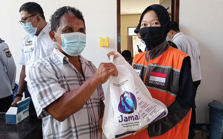 Salah satu sopir angkot saat menerima bantuan Si Jamal dari petugas. (foto: ist)