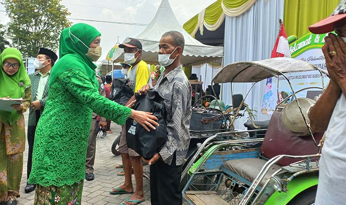 Gubenur Jawa Timur, Khofifah Indar Parawansa, saat memberikan paket sembako kepada para tukang becak di Kabupaten Mojokerto.