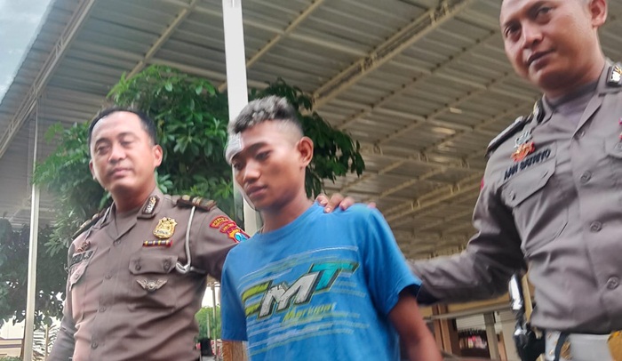Joki drag race Aditya alias Ucil ditangkap di Pasuruan dan dibawa ke Polresta Sidoarjo. Ucil diapit petugas Satlantas Polresta Sidoarjo