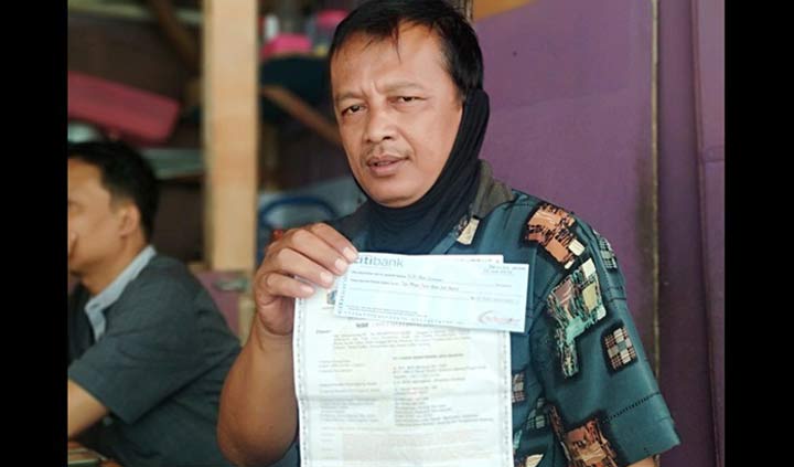 Karlin, tukang ojek online di Pacitan menunjukan bukti cek dan SIUP yang ia temukan. foto: YUNIARDI SUTONDO/ BANGSAONLINE