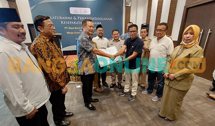 Komisaris PT RBNP, Bambang Setyobudi, menyerahkan surat tanah kepada perwakilan warga Green Garden Regency dan disaksikan Bupati Gresik, Fandi Akhmad Yani. Foto: SYUHUD/BANGSAONLINE