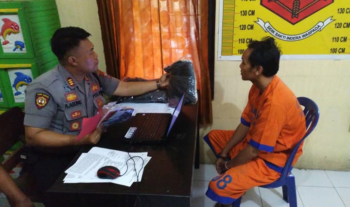 Kapolsek Wonoayu AKP Anak Agung Gede PW saat menginterogasi tersangka sambil menunjukkan barang bukti berupa tas pinggang.