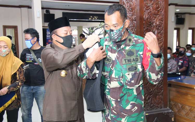Bupati Fadeli secara langsung mengukuhkan penegak disiplin melalui pemasangan rompi satgas.