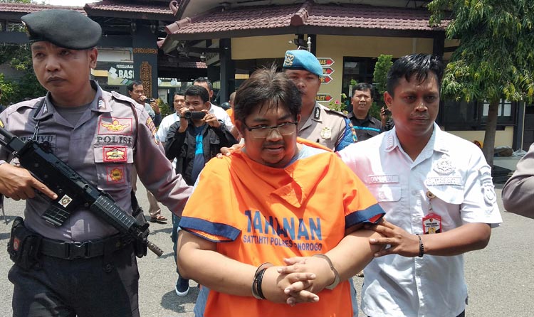 Petugas Polres Ponorogo menggelandang Galih Kusuma, otak pelaku kasus investasi bodong berkedok sapi perah.
