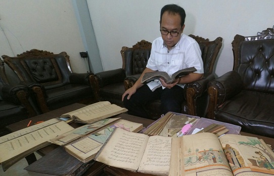 Agus Sulton saat menunjukkan kitab koleksinya. foto: RONY S/ BANGSAONLINE