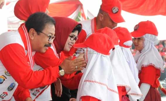 Pakde dan Bude Karwo menerima PIN anti korupsi dari perwakilan siswi SD se jatim. foto: nisa/ BANGSAONLINE