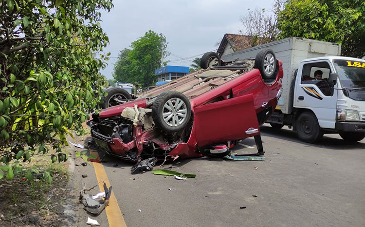 Mobil Suzuki Ertiga nopol S 1658 SR yang menabrak pembatas jalan dan pohon hingga terbalik. (foto: ist)