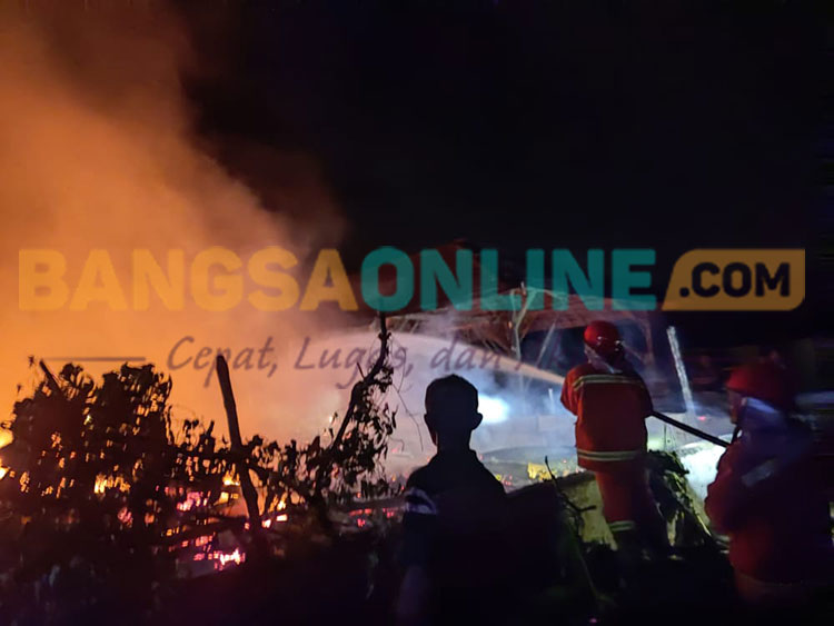 Tim Damkar Tuban saat melakukan pemadaman api di rumah Pangi (67) warga Desa Katerban, Kecamatan Senori, Kabupaten Tuban, hangus terbakar, Minggu (18/9/2022). Foto : Gunawan Wihandono/BANGSAONLINE.com