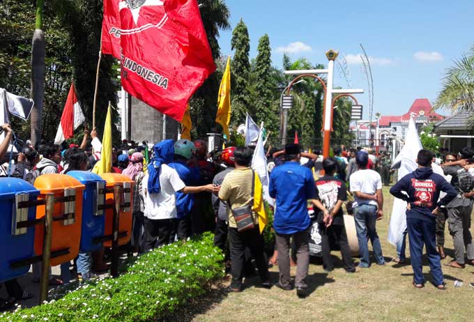 Aksi demo menolak revitalisasi alun-alun di depan kantor Pemkab Gresik. foto: SYUHUD/ BANGSAONLINE