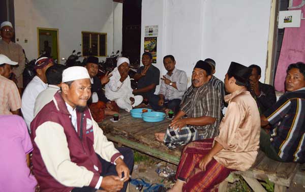 Ra Fadil (tengah, baju putih celana hitam) saat ngopi berbaur bersama warga di Besuki. (foto: hadi prayitno/BANGSAONLINE)