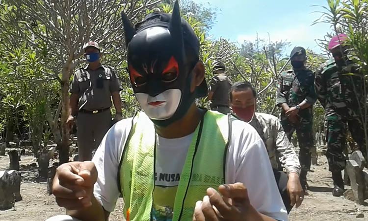 Langgar Protokol Kesehatan, Warga Sidoarjo Disanksi Bersihkan Makam Pakai Topeng Superhero