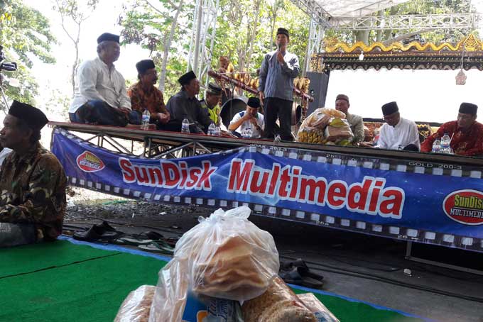 Camat Kebomas Sutrisno saat memberikan sambutan di acara sedekah bumi di Dusun Srembi, Desa Kembangan. foto: SYUHUD/ BANGSAONLINE