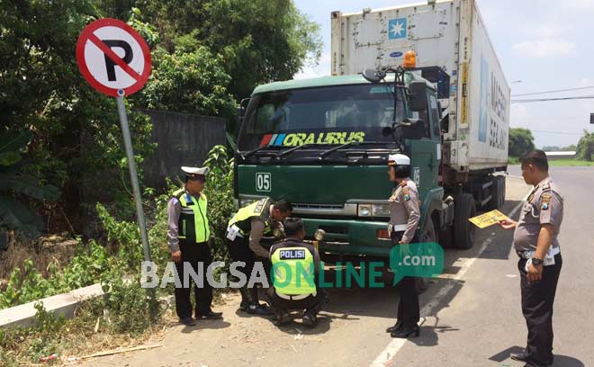 Polisi melakukan penindakan terhadap truk yang parkir di ring road Mojoagung, Rabu (21/9). foto: ROMZA/ BANGSAONLINE