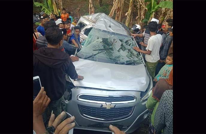 Warga berusaha mengevakuasi korban yang sempat terjebak di dalam mobil.