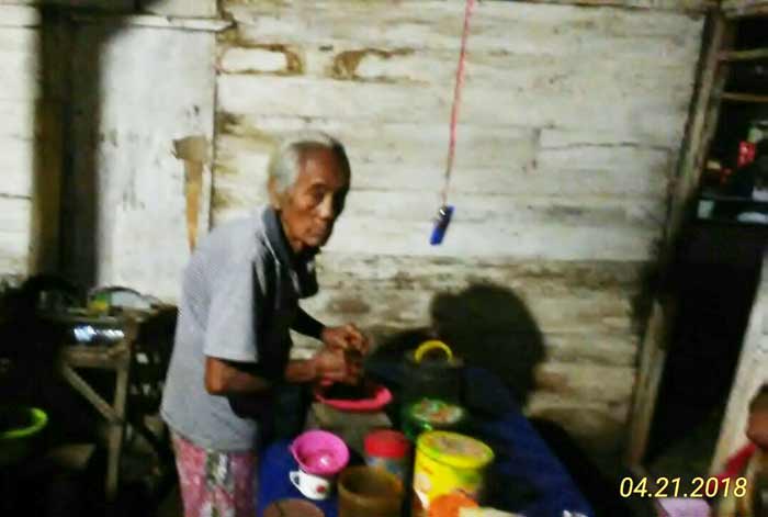 Mbah Nasri tengah menyajikan kopi untuk pelanggan warungnya.