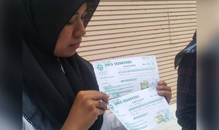 Salah satu korban menunjukkan bukti kwitansi.