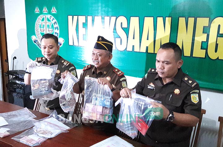 Kajari Pandu Pramoekartika didampingi Kasie Pidsus Andrie Dwi Subianto saat menunjukkan barang bukti OTT Rp 537 juta. foto: SYUHUD/ BANGSAONLINE
