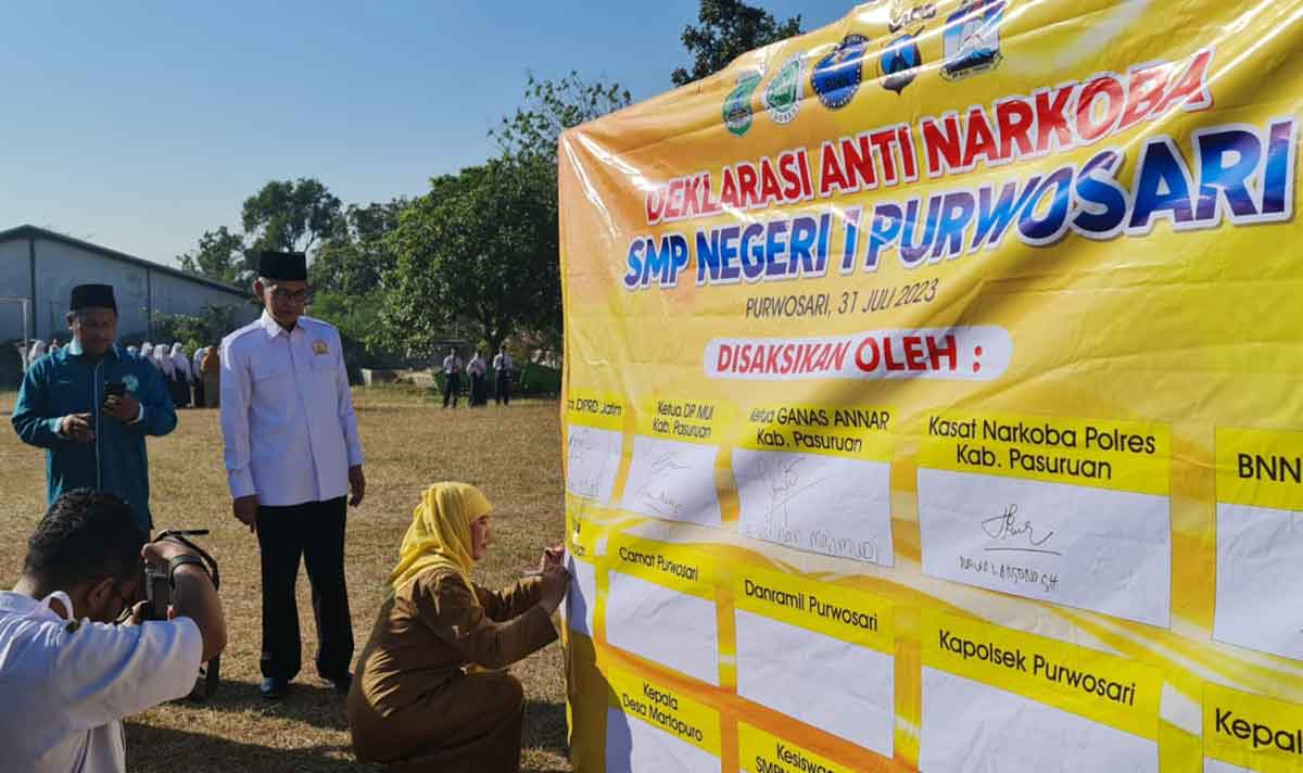 Anggota DPRD Jatim, Muzammil Syafi'i, bersama Ketua MUI Kabupaten Pasuruan, Nurul Huda, ketika menandatangani papan dalam sosialisasi bahaya narkoba di SMPN 1 Purwosari.