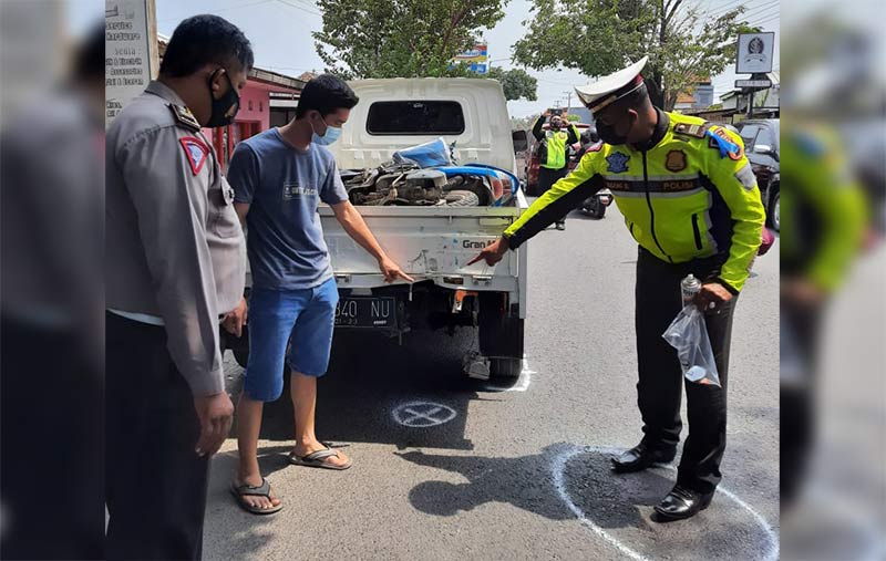 Petugas saat melakukan olah TKP menunjukkan bagian pikap yang ditabrak.