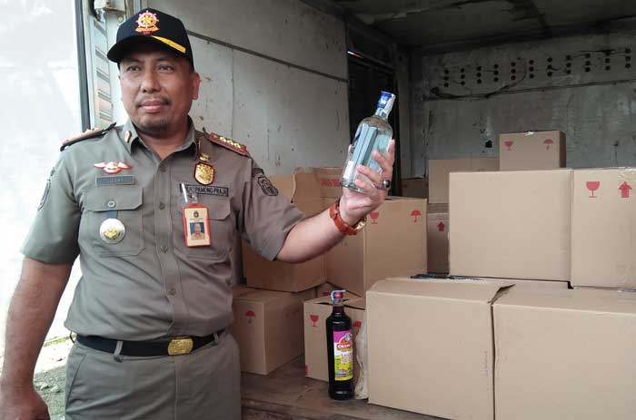 Plt Kasatpol PP Kota Blitar Juari menunjukkan miras yang diamankan.