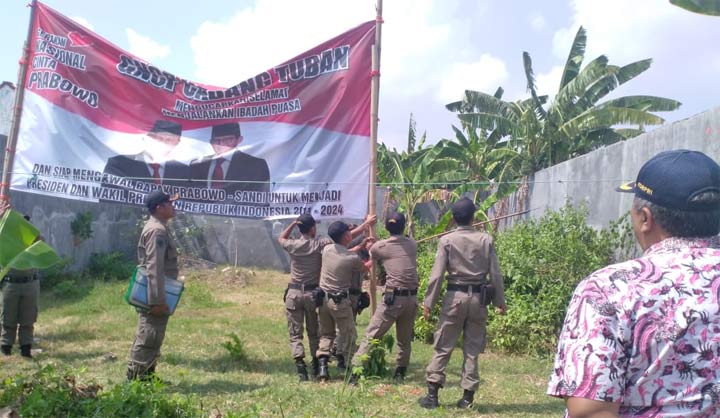 Petugas Satpol PP saat menurunkan banner yang diduga dipasang relawan Prabowo-Sandi.