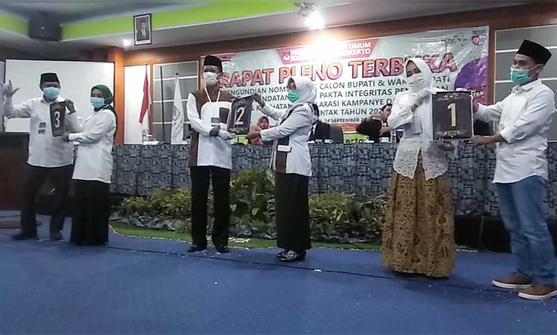 Ketiga paslon menunjukkan nomor urut yang didapat.