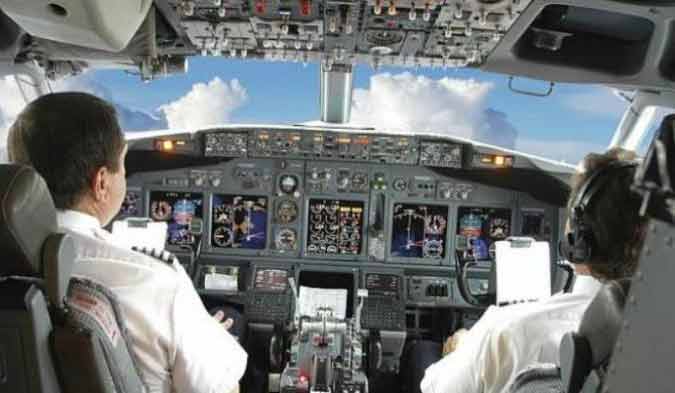 Pilot dan co pilot sedang berada di kokpit pesawat.